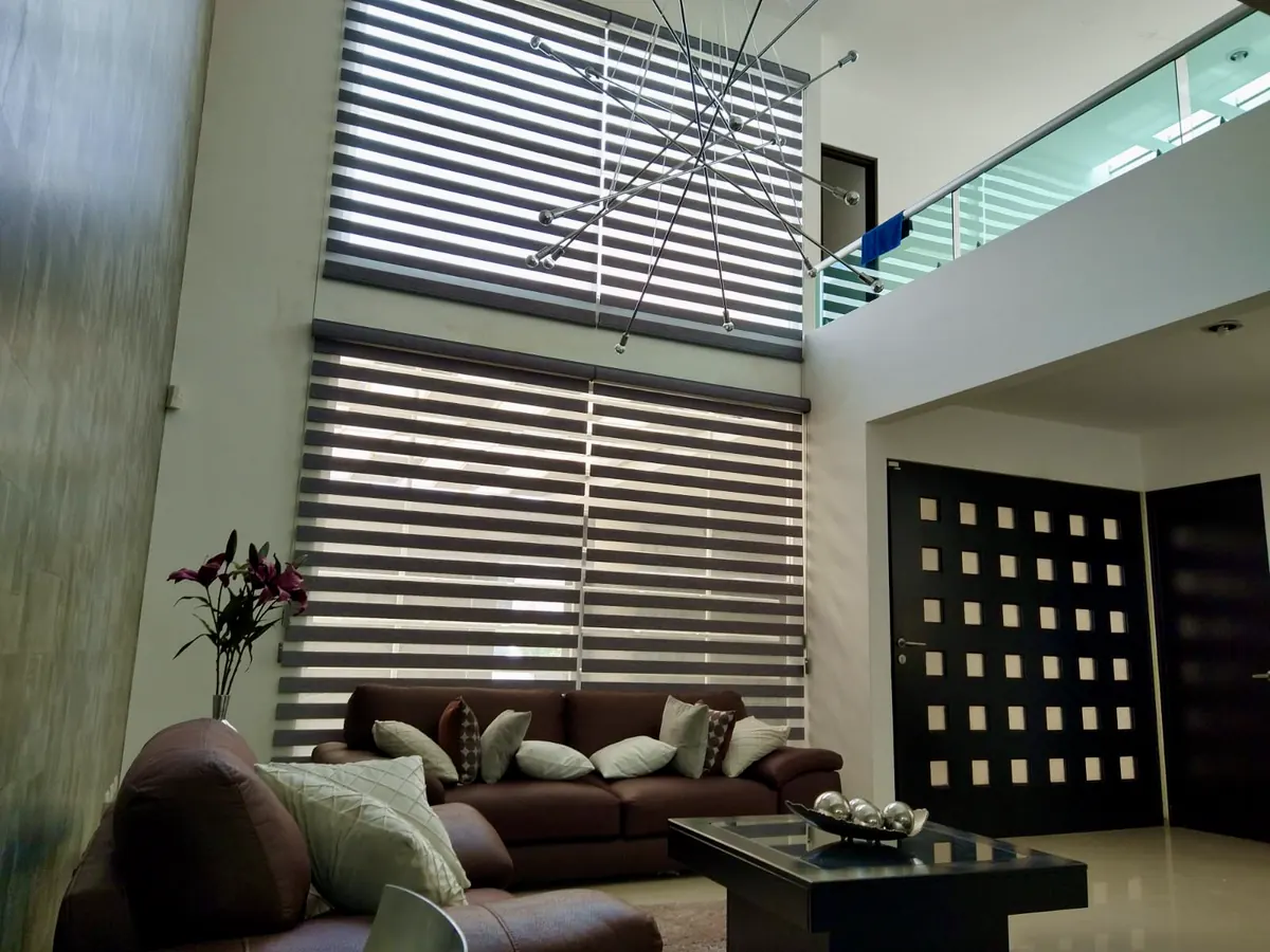 Sala de doble altura con persianas traslúcidas
